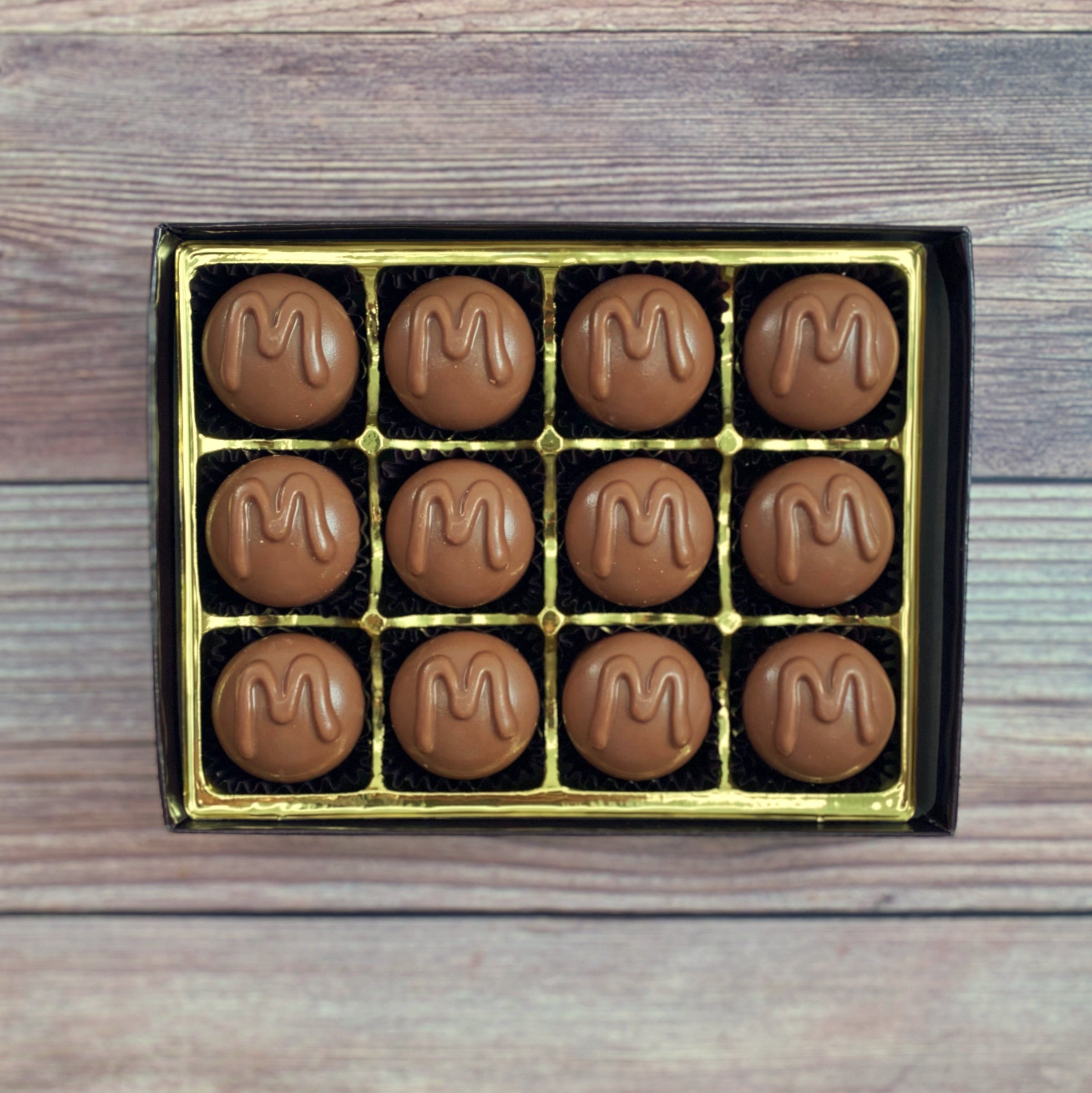 A box of chocolate maple butter creams with a golden interior.